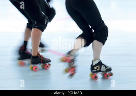 Roller derby skaters close up. Action motion blur pan shot of legs and feet. Stock Photo