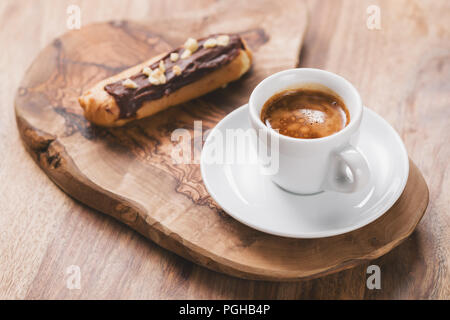 espresso with eclair on wooden board, breakfast Stock Photo