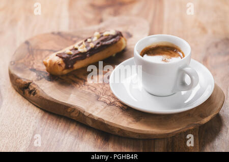 espresso with eclair on wooden board, breakfast Stock Photo