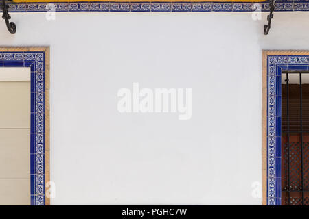 Stylish Mediterranean carved shutters with a white wall in the middle Stock Photo