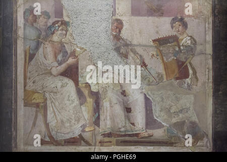 Ancient Roman musicians depicted in the Roman fresco from Herculaneum (1-79 AD), now on display in the National Archaeological Museum (Museo Archeologico Nazionale di Napoli) in Naples, Campania, Italy. Seated woman appears to be reading the musical score being played by the musicians on a tibia (Roman double flute) and a cithara (Roman lyre). Stock Photo