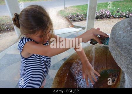 Young girl at a mineral spring fountain tap in spa town Karlovy Vary Czech Republic Stock Photo