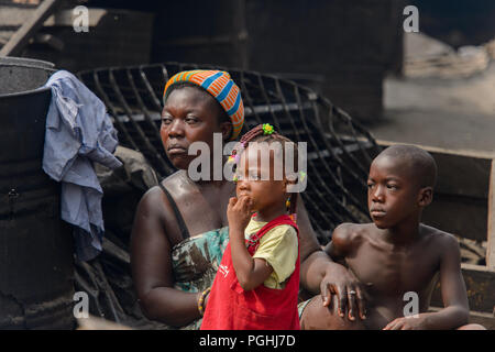 ACCRA, GHANA - Jan 8, 2017: Unidentified Ghanaian woman with her children sit at the local market. People of Ghana suffer of poverty due to the econom Stock Photo