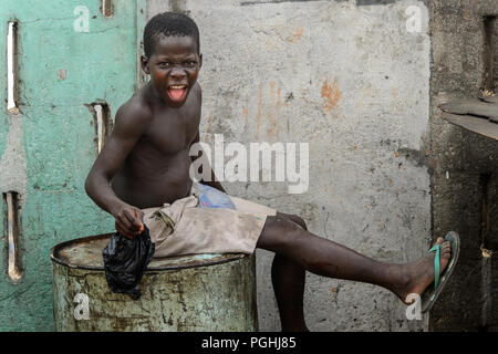 ACCRA, GHANA - Jan 8, 2017: Unidentified Ghanaian boy shouts at the local market. People of Ghana suffer of poverty due to the economic situation Stock Photo