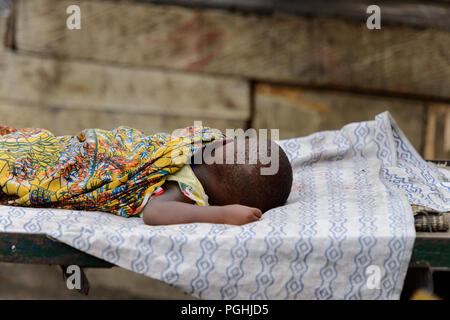 ACCRA, GHANA - Jan 8, 2017: Unidentified Ghanaian boys walk at the local market. People of Ghana suffer of poverty due to the economic situation Stock Photo