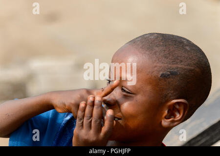 ACCRA, GHANA - Jan 8, 2017: Unidentified Ghanaian boy smiles at the local market. People of Ghana suffer of poverty due to the economic situation Stock Photo