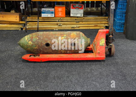 The painted body of a 500 pound aircraft bomb with double fuze pockets for sale at the Detling militaria show in Kent sat on a pallet truck. Stock Photo