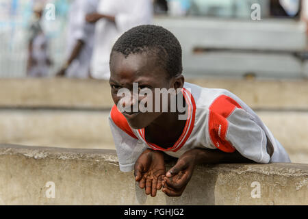 ACCRA, GHANA - Jan 8, 2017: Unidentified Ghanaian boy frowns at the local market. People of Ghana suffer of poverty due to the economic situation Stock Photo