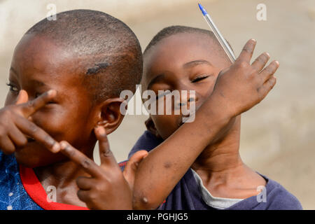 ACCRA, GHANA - Jan 8, 2017: Unidentified Ghanaian kids play at the local market. People of Ghana suffer of poverty due to the economic situation Stock Photo