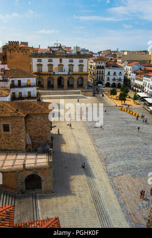 Aerial view of Plaza Mayor in Caceres during a beautiful and sunny day. Town hall view. Monumental walled square full of ancient buildings and people. Stock Photo
