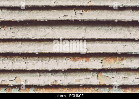 Ventilation mesh on the wall painted with white shabby paint as background. Grunge texture with close up detail Stock Photo