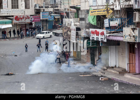 Hebron, Palestine, November 29, 2013: Young Palestinians are standing on the streets amid tear gas during riots in Hebron’s old town. Stock Photo