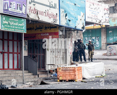 Hebron, Palestine, November 29, 2013:  Israel Defence Forces soldiers are moving forward through the streets pushing off Palestinians during riots in  Stock Photo