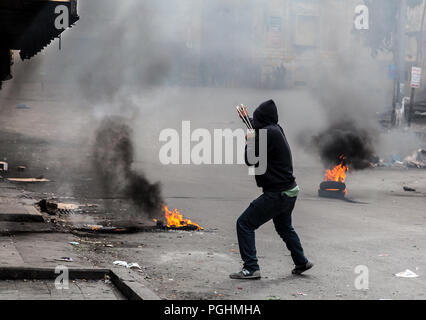 Hebron, Palestine, November 29, 2013:  Young Palestinians is shooting a stone from a sling towards Israeli soldiers during riots in Hebron’s old town. Stock Photo