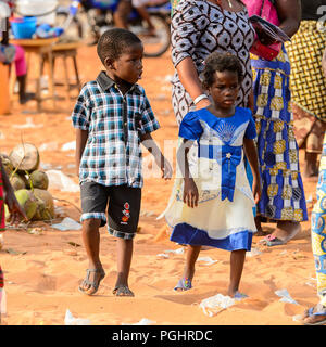 OUIDAH, BENIN - Jan 10, 2017: Unidentified Beninese children walk at the local market. Benin children suffer of poverty due to the bad economy Stock Photo