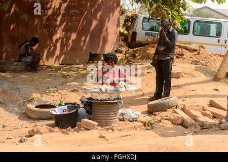 CENTRAL REGION, GHANA - Jan 17, 2017: Unidentified Ghanaian woman chops some vegetable in local village. People of Ghana suffer of poverty due to the  Stock Photo