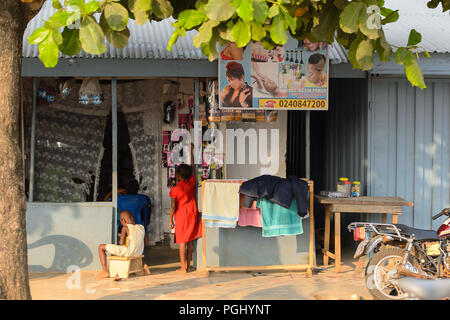 CENTRAL REGION, GHANA - Jan 17, 2017: Unidentified Ghanaian children near the barbershop in local village. Children of Ghana suffer of poverty due to  Stock Photo