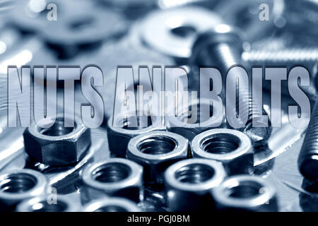 Nuts and bolts written on top of washers, nuts and bolts in blue background Stock Photo
