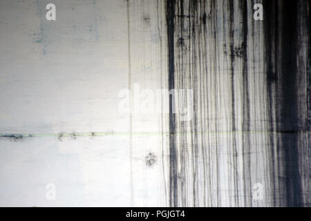 The close-up of a bright wall with black lines of leaked paint on the wall. Stock Photo