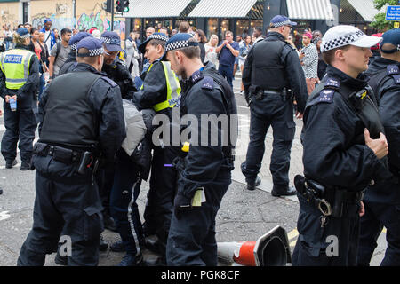 London UK 27th August 2018 Police were pictured carrying out stop-and-search at the Notting Hill Carnival after being handed extra powers in a bid they say to curb violent crime. Police stop and search young black men at the annual Notting Hill Carnival. For many victims of this experience it is a source of anger and frustration as they feel targetted due to their skin colour. Credit: Thabo Jaiyesimi/Alamy Live News Stock Photo