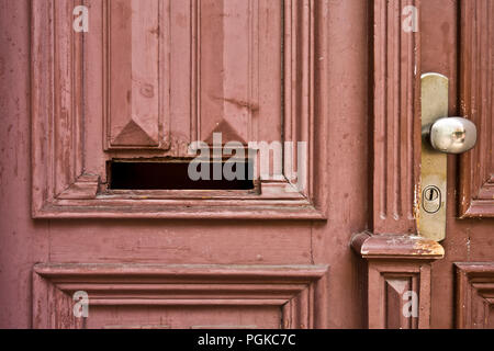 a mail slot in an old wooden door Stock Photo