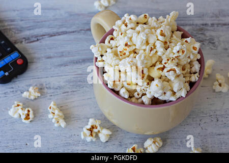 A bowl of delicious caramel popcorn on a white wooden background Stock Photo