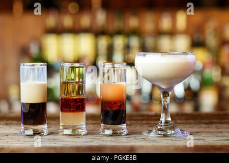 https://l450v.alamy.com/450v/pgke8b/different-club-cocktails-for-men-and-women-in-different-glasses-stand-on-a-bar-counter-on-a-blurred-background-of-alcohol-pgke8b.jpg