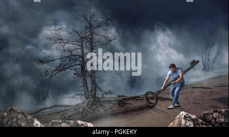 Man drags a huge key in dry desert at the night. Hard way to freedom concept Stock Photo