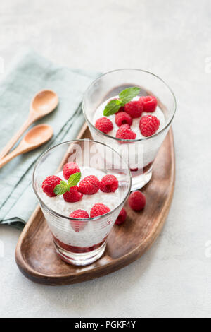 Chia pudding with raspberries in a glass on wooden serving board. Top view, selective focus Stock Photo