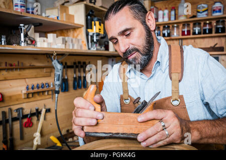 caucasian carpenter at work with planer in a workshop Stock Photo