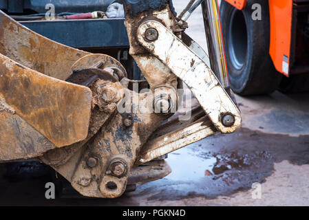 bulldozer, excavator close-up, heavy metal equipment with iron ladle and large wheels at work in the sand quarry, excavations of sand, earth and soil, industrial site, construction site Stock Photo