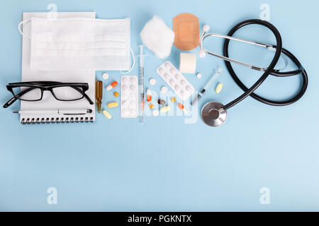 Medical objects flat lay blue background syringes pills and ampoule Stock Photo
