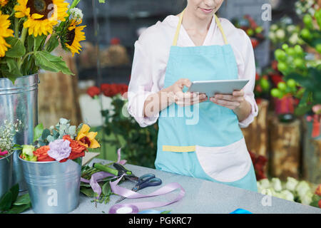 Mid section portrait of unrecognizable florist using digital tablet in shop Stock Photo