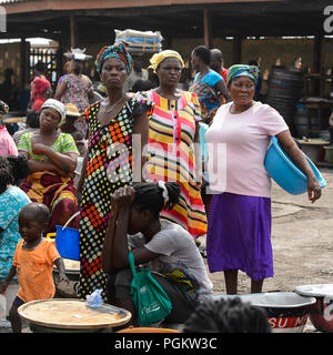 ELMINA, GHANA -JAN 18, 2017: Unidentified  Ghanaian women in colored clothes gather near Elmina port. People of Ghana suffer of poverty due to the bad Stock Photo