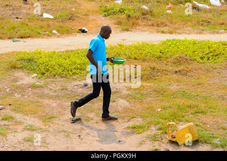 ELMINA, GHANA -JAN 18, 2017: Unidentified  Ghanaian man walks along the street of Elmina. People of Ghana suffer of poverty due to the bad economy Stock Photo