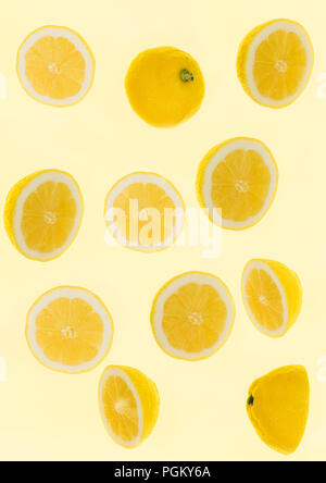 frontal view of lemons cut in half floating in a yellow background Stock Photo