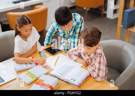 Smart children studying foreign languages in a classroom Stock Photo