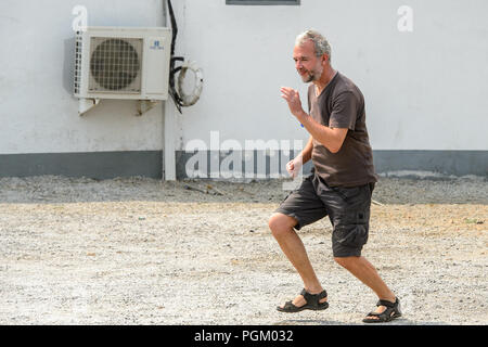 CENTRAL REGION, GHANA - Jan 17, 2017: Unidentified European tourist runs in local village. Stock Photo