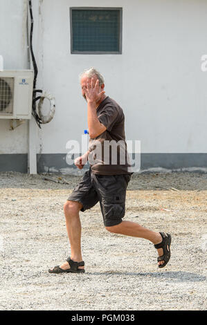 CENTRAL REGION, GHANA - Jan 17, 2017: Unidentified European tourist runs in local village. Stock Photo