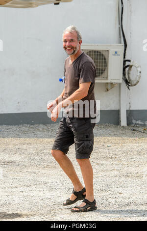 CENTRAL REGION, GHANA - Jan 17, 2017: Unidentified European tourist runs in local village. Stock Photo