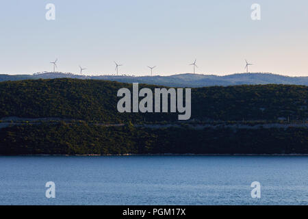 Wind turbines on hill above the sea. Copy space Stock Photo