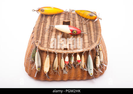 A selection of old fishing lures, or plugs, displayed on an old whicker  fishing creel. From a collection of fishing tackle and sporting collectibles  Stock Photo - Alamy