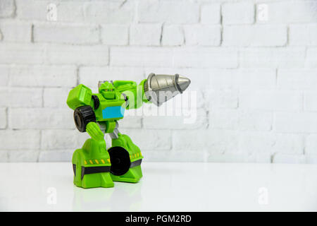 Green plastic kids toy robot on a white reflective shelf Stock Photo