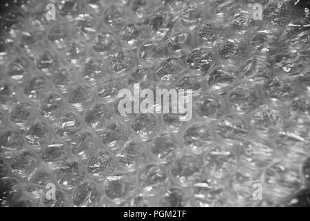 Bubble wrap texture used for packaging fragile items on grey background Stock Photo