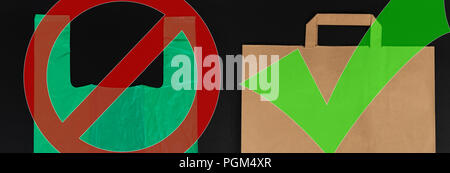 Biodegradable versus single use waste choice concept with green plastic and brown paper bags isolated on black background Stock Photo