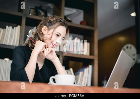 Confident happiness young woman working on laptop or notebook in her office. Beautiful Freelancer Woman working online at her home. Beauty Asian busin Stock Photo