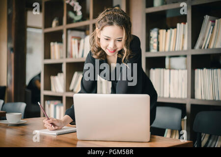 Beautiful Freelancer Woman working online at her home. Stock Photo
