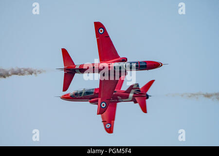 The RAF Red Arrows synchro pair aircraft perform the opposition pass at the Dunsfold Wings & Wheels Airshow, UK on the afternoon of 25th August 2018. Stock Photo