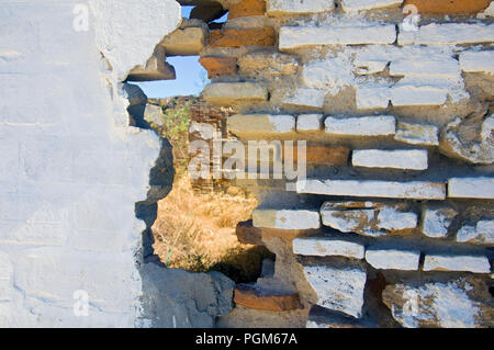 Hole in the different structured wall, dry grass Stock Photo