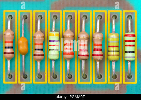 colored resistors in a row soldered on a printed circuit board Stock Photo